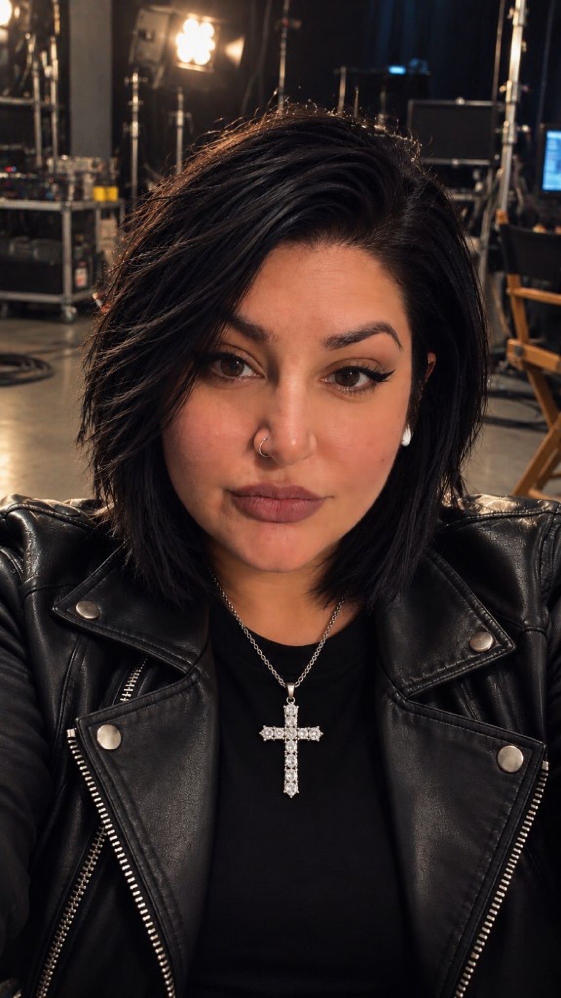 Jackie Jorge on a film set, in a black leather jacket with a silver cross.
